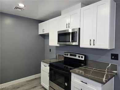 Kitchen with visible vents, baseboards, light wood