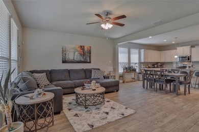 Living area with light wood-type flooring, ceiling fan, and recessed lighting