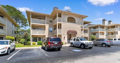 View of apartment building / complex featuring uncovered parking