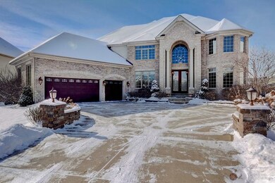 Brick and stone elevation with grand entryway.