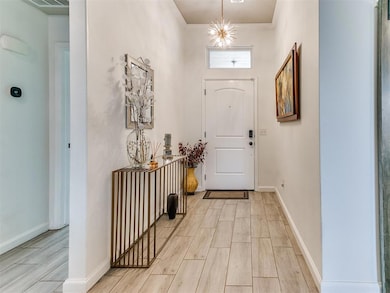 Foyer with light wood finished floors and crown molding