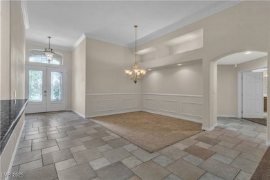 Foyer featuring a notable chandelier, crown moldin