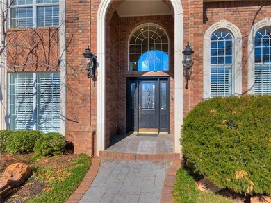 A brick-and-stone path leads to the large arched e