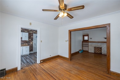 Dining room with hardwood floors, ornamental molding, and a ceiling fan