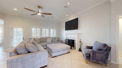 Living area with ornamental molding, light tile patterned floors, ceiling fan, a fireplace, and recessed lighting