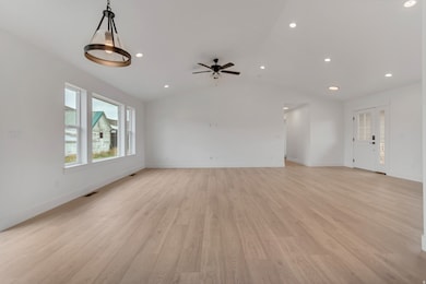 Unfurnished living room with light wood-type flooring, lofted ceiling, recessed lighting, and a ceiling fan