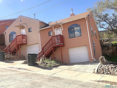 View of front of house with an attached garage, stucco siding, concrete driveway, and a chimney