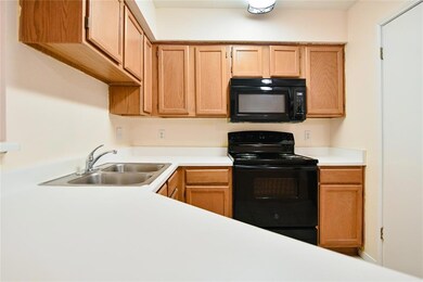 Kitchen featuring black appliances, a sink, and l