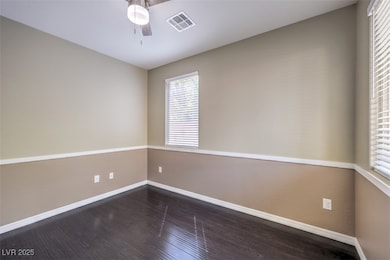 Empty room featuring baseboards, ceiling fan, wood