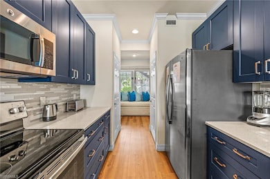 Kitchen featuring crown molding, light hardwood / 