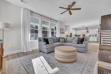 Living room with ceiling fan and light wood-type f