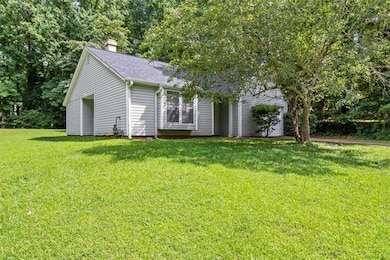 View of front facade featuring a chimney, a front lawn, and roof with shingles