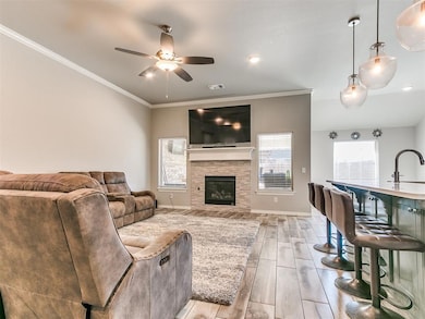 Living room featuring a stone fireplace, sink, cei