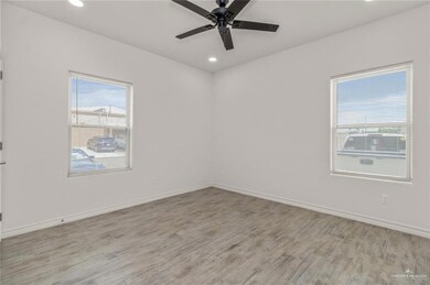 Spare room with healthy amount of natural light, light wood-type flooring, ceiling fan, and recessed lighting