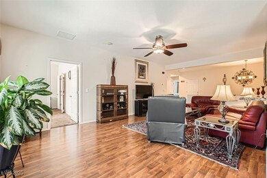 Living room with ceiling fan with notable chandeli