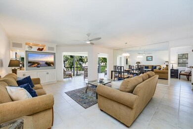 Living area with plenty of natural light, ceiling fan with notable chandelier, visible vents, and light tile patterned floors