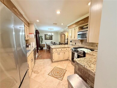Kitchen featuring stainless steel appliances, crown molding, granite, a chandelier, decorative backsplash, and recessed lighting