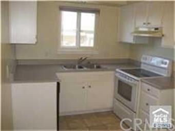 Clean and bright kitchen with electric oven and di