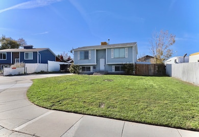 Split foyer home featuring a chimney and concrete driveway