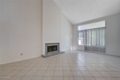 Unfurnished living room with high vaulted ceiling,