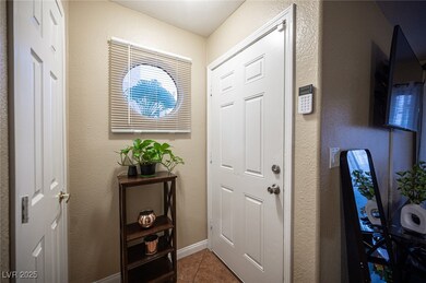 Entryway featuring a textured wall and tile patterned flooring