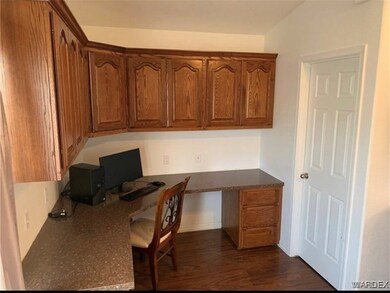 Home office with built in desk and dark wood-type