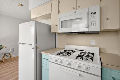 Kitchen featuring white appliances, light wood-ty