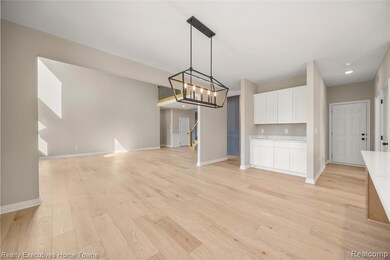 Unfurnished dining area with a chandelier, light wood finished floors, and stairs