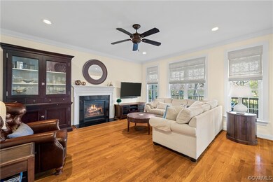 Living room featuring crown molding, ceiling fan,