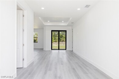 Empty room featuring a raised ceiling, recessed li
