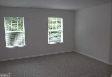 Spare room featuring carpet and baseboards