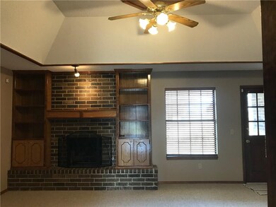 Living room with gas log fireplace and bookcases. 
