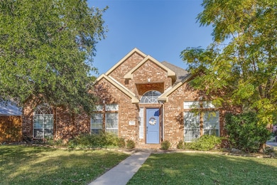 View of front of property featuring brick siding and a front lawn
