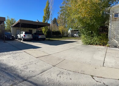 View of vehicle parking with driveway and a carport