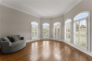 Living area with crown molding and wood finished floors