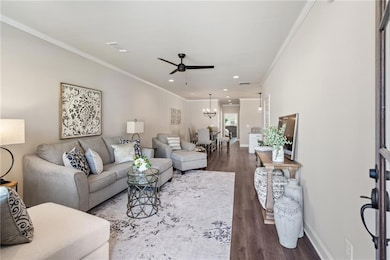 Living room with wood-type flooring, crown molding