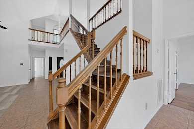 Staircase with a high ceiling and tile patterned flooring
