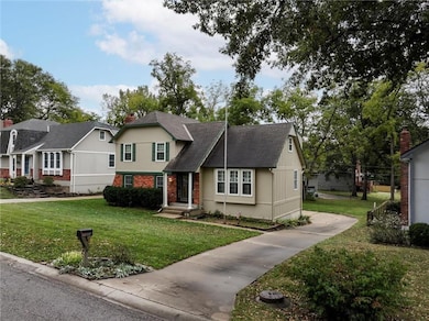 View of front of property with a front lawn, brick and stucco siding