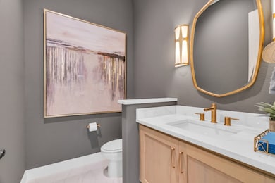 Powder room with beautiful wall sconces and a bras