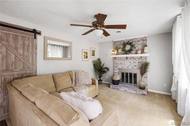 Living room with carpet, a brick fireplace, brick