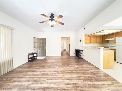 Unfurnished living room featuring light wood-style floors and a ceiling fan