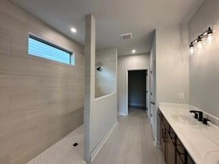 Full bathroom featuring walk in shower, double vanity, wood finished floors, and recessed lighting