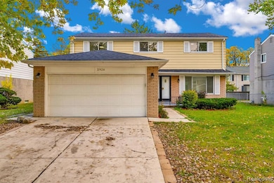Traditional home featuring brick siding, driveway, and an attached garage