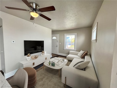 Living room with a textured ceiling and ceiling fan