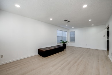 Living/dining area featuring recessed  LED lighting, window blinds and luxury laminate flooring.