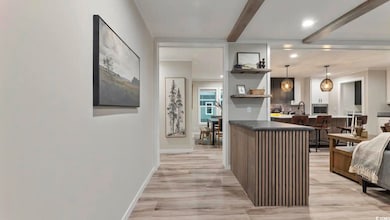 Kitchen featuring open shelves, beam ceiling, light wood-style floors, recessed lighting, and decorative light fixtures
