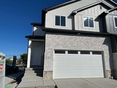 View of front of house with stone siding, an attached garage, and concrete driveway