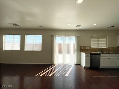 Kitchen featuring white cabinetry, dishwasher, dark wood-type flooring, recessed lighting, and light stone counters