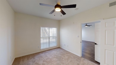Spare room with carpet flooring, visible vents, an
