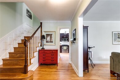 The foyer has a large entryway into the living room, and access to the kitchen.